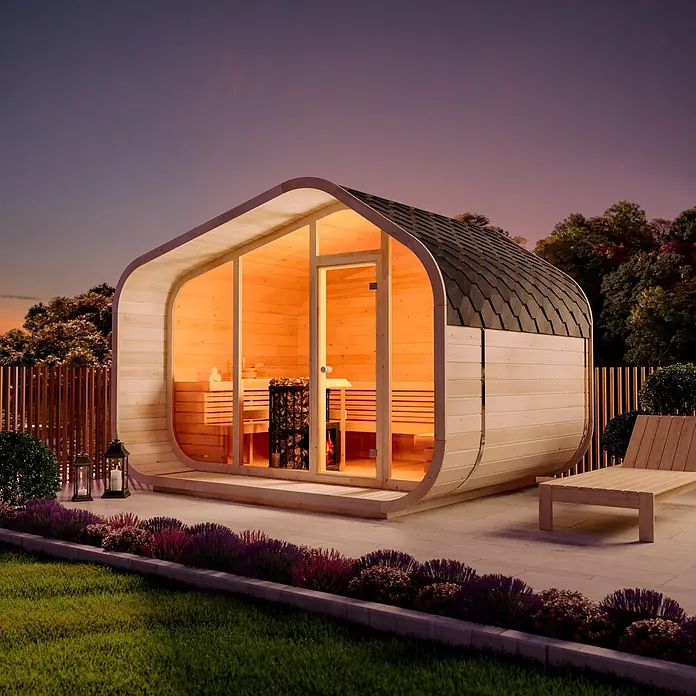FinnTherm Fasssauna ScandiCube Wave Premium - Holz, L x B x H: 286 x 38 x 264 cm - Moderne Gartensauna aus hellem Holz mit dunklem Dach, innen warm leuchtend im Abendlicht.