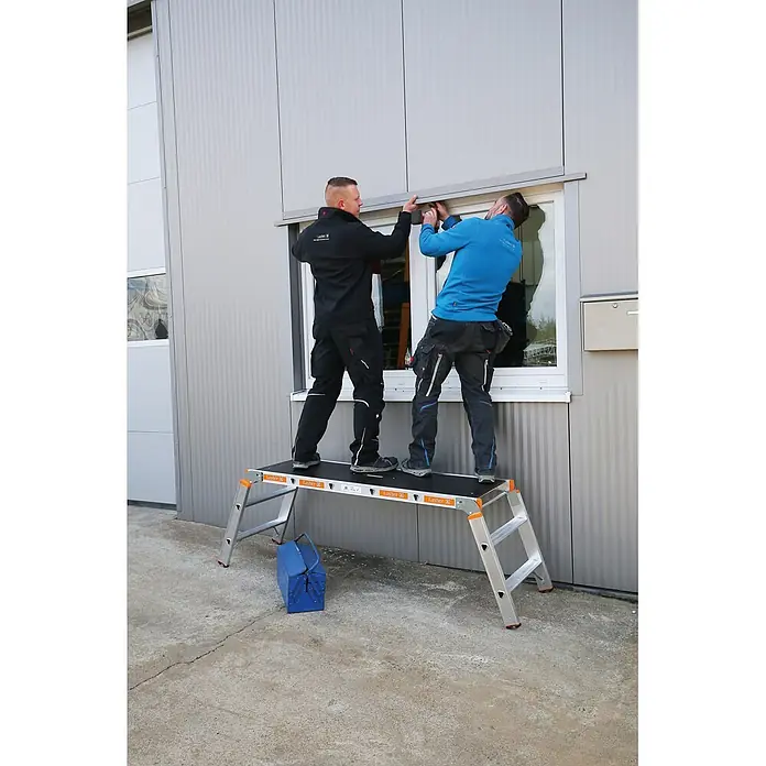 Layher Arbeitsplattform Arbeitsplattform TOPIC 1065 klappbar - Anzahl Tritte: 3 Stk., Arbeitshöhe: 2.650 m, Aluminium - Zwei Männer stehen auf einer silber-schwarzen Arbeitsplattform und installieren etwas über einem Fenster.