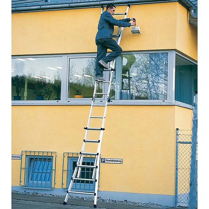 Zarges Anlegeleiter Teleskop-Mehrzweckleiter Variomax V 4x3 Sprossen - Anzahl Tritte: 3 Stk., Arbeitshöhe: 3.850 m, Aluminium - Mann auf hoher, mehrteiliger Aluminiumleiter, arbeitet an einer Gebäudeaußenwand.