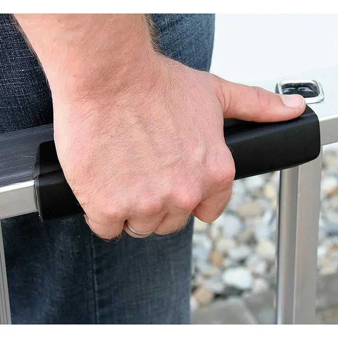 Munk Anlegeleiter Stufenanlegeleiter mit Ergo-Pad ohne Traverse 8 Stufen - Anzahl Tritte: 8 Stk., Arbeitshöhe: 3.300 m, Aluminium - Hand hält schwarzen ergonomischen Griff an einer silbernen Leiter.