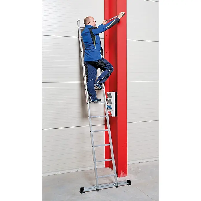 Euroline Anlegeleiter Premium 301 Sprossenanlegeleiter 24 Sprossen - Anzahl Tritte: 24 Stk., Arbeitshöhe: 8.050 m, Aluminium - Mann steht auf einer silbernen Aluminiumleiter und misst einen roten Pfeiler mit einem Maßband.