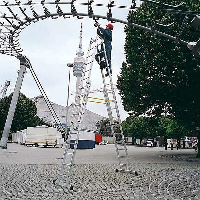 Zarges Mehrzweckleiter Sprossen-Stehleiter Vario B 4x12 Sprossen - Anzahl Tritte: 12 Stk., Arbeitshöhe: 7.000 m, Aluminium - Arbeiter benutzt eine hohe, ausziehbare silberne Aluminiumleiter für Überkopfarbeiten.