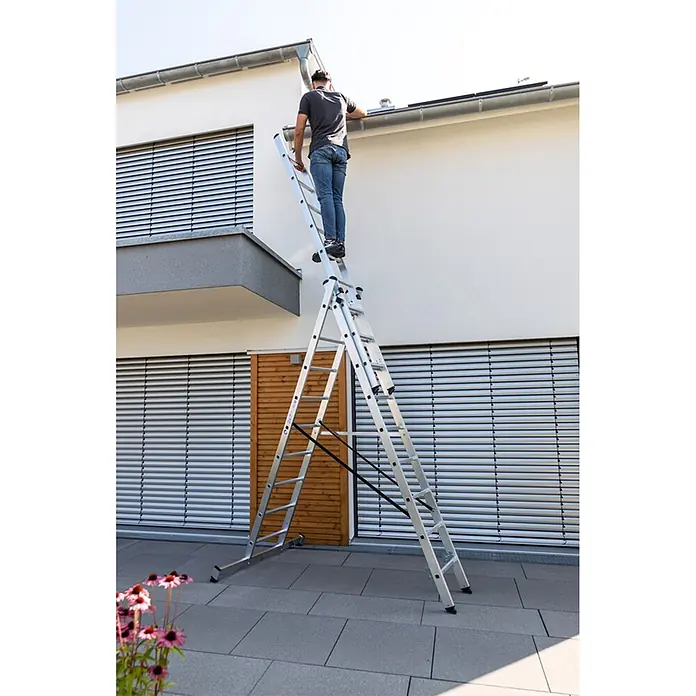 Munk Mehrzweckleiter Mehrzweckleiter mit Nivello® Traverse 3x7 Sprossen - Anzahl Tritte: 7 Stk., Arbeitshöhe: 6.100 m, Aluminium - Mann auf einer ausgefahrenen Aluminium-Mehrzweckleiter reinigt Hausrinnen.