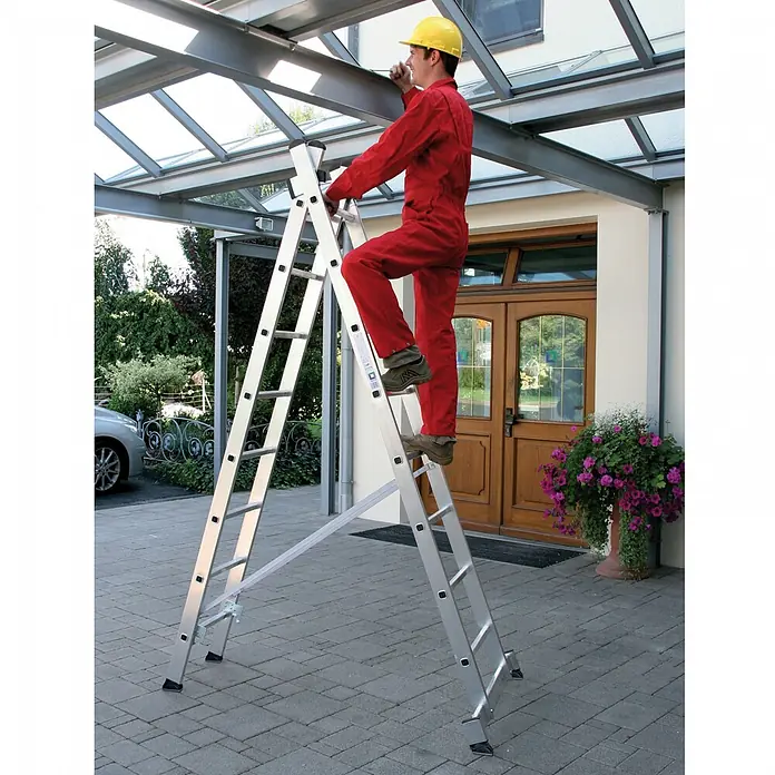 Munk Mehrzweckleiter Mehrzweckleiter 2-teilig 2x10 Sprossen - Anzahl Tritte: 10 Stk., Arbeitshöhe: 6.100 m, Aluminium - Silberne Aluminium-Mehrzweckleiter wird von einer Person in rotem Overall an einer Glasdachkonstruktion verwendet.