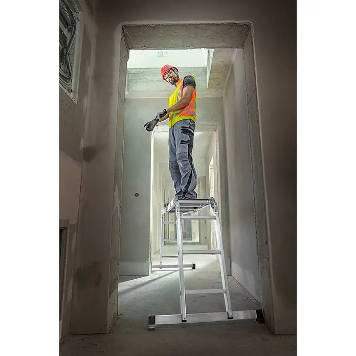 Werner Mehrzweckleiter Vielzweckleiter 4-teilig mit Plattform - Anzahl Tritte: 3 Stk., Arbeitshöhe: 4.540 m, Aluminium - Bauarbeiter nutzt eine Aluminium-Arbeitsplattform für sichere Arbeiten in der Höhe in einem Rohbau.