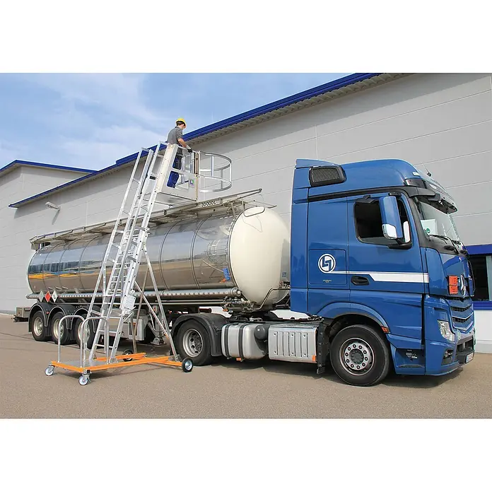 Munk Mehrzweckleiter Tankwagenleiter mit Sprossen Typ 2 - Arbeitshöhe: 5.400 m, Aluminium - Mobile Tankwagen-Einstiegsleiter aus Aluminium mit orangefarbener Basis, ein Arbeiter, der den oberen Bereich eines blauen Tankwagens erreicht.