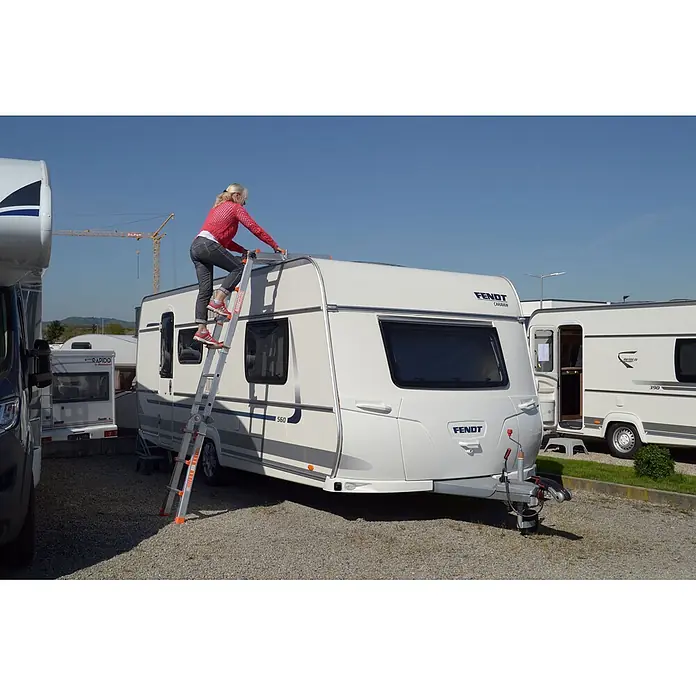 Siedra-Leitern Dachleiter Caravanleiter Sicherheitsleiter 977 4x4 Sprossen - Anzahl Tritte: 4 Stk., Arbeitshöhe: 4.200 m, Aluminium - Silberne Teleskopleiter im Einsatz, eine Frau steigt damit auf das Dach eines weißen Wohnwagens.