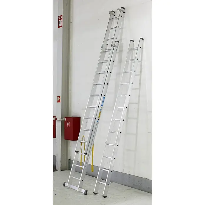 Zarges Mehrzweckleiter Skymaster X Mehrzweckleiter 3x14 Sprossen - Anzahl Tritte: 14 Stk., Arbeitshöhe: 10.350 m, Aluminium - Zwei Aluminium-Anlegeleitern mit Sicherheitsgurten lehnen an einer Wand.