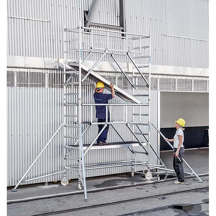 Zarges Rollgerüst Fahrgerüst MultiTower S-PLUS 1T mit Auslegern 2,50m Plattformlänge 6,45m - Arbeitshöhe: 6.450 m - Zwei Arbeiter montieren ein fahrbares Aluminiumgerüst.
