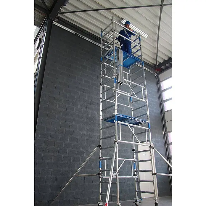 ASC Rollgerüst Rollgerüst XS-Tower (DIN EN 1004:2004) - Arbeitshöhe: 6.200 m - Mobiles Aluminium-Rollgerüst mit blauen Plattformen, von einer Person bei Arbeiten in der Höhe genutzt.