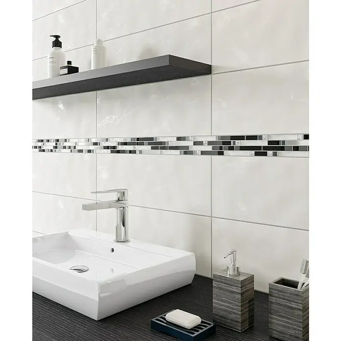 Mosaikfliese Crystal Mix - 29,8 x 33,8 cm, Schwarz, Glänzend - Das Bild zeigt ein modernes Badezimmer mit einem weißen Waschbecken, einer dunklen Ablage und Fliesen mit Mosaikstreifen.