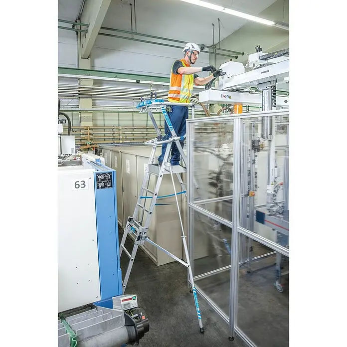 Zarges Teleskopleiter Teleskop Plattformleiter ZAP MASTERFLEX S 7-9 Sprossen - Anzahl Tritte: 7 Stk., Arbeitshöhe: 4.300 m, Belastbarkeit: 150 kg, Aluminium - Arbeiter auf einer silbernen Aluminium-Mehrzweck-Arbeitsplattform mit blauen Akzenten, der Industriemaschinen bedient.