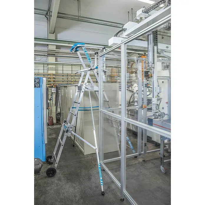 Zarges Teleskopleiter Teleskop Plattformleiter ZAP MASTERFLEX S 7-9 Sprossen - Anzahl Tritte: 7 Stk., Arbeitshöhe: 4.300 m, Belastbarkeit: 150 kg, Aluminium - Bewegliche ZARGES Plattformleiter aus Silberaluminium mit blauen Akzenten, in industrieller Umgebung neben Maschinen, für Zugang zu Arbeitshöhen.