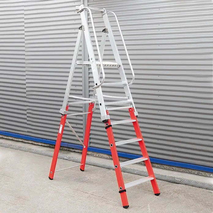 Munk Podestleiter Einsteckteil Plus 4 Stufen für steckbare Plattformleiter - Aluminium - Eine Aluminium-Klappleiter mit roten Standbeinen und Handläufen steht auf Beton.
