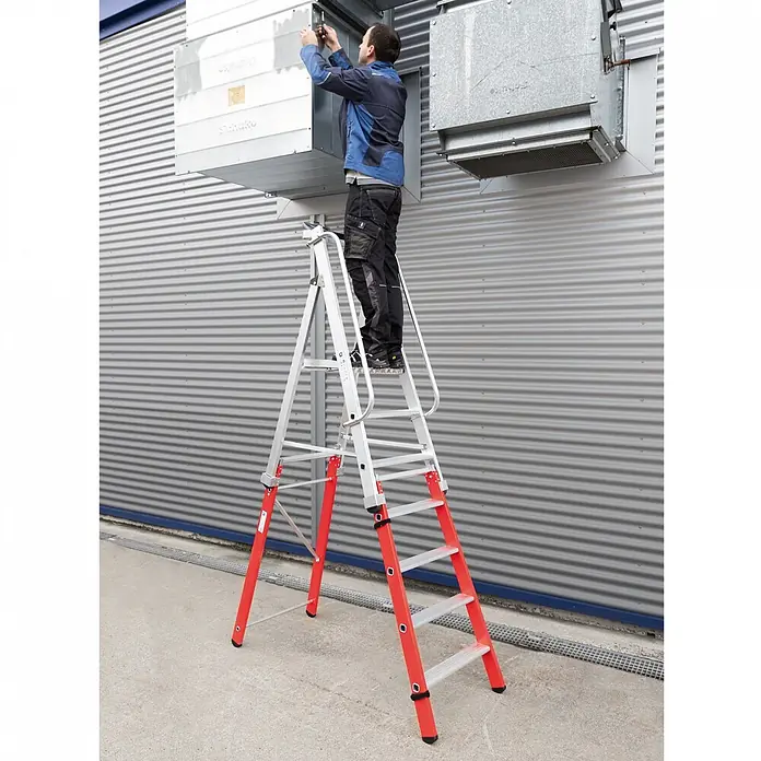 Munk Podestleiter Einsteckteil Plus 4 Stufen für steckbare Plattformleiter - Aluminium - Mann auf silber-roter Stehleiter mit Handläufen, der an einer Lüftungsanlage arbeitet.
