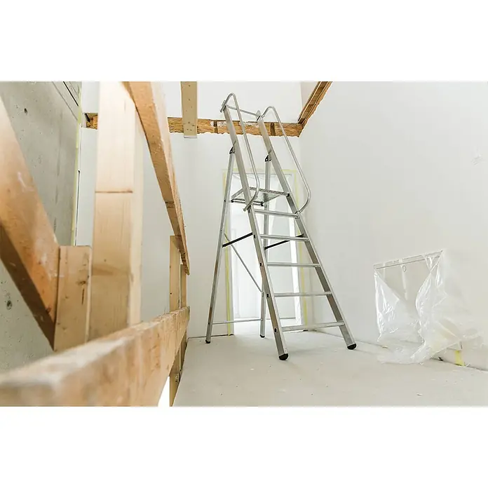 Munk Stehleiter ML Bauleiter Aluminium-Stufenstehleiter 7 Stufen - Anzahl Tritte: 4 Stk., Arbeitshöhe: 3.850 m, Aluminium - Silberne Aluminium-Sicherheitsstehleiter mit Plattform und Handläufen, in einem Raum unter Renovierung verwendet.
