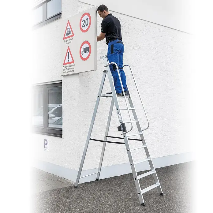 Munk Stehleiter Aluminium-Stehleiter 7 Stufen - Anzahl Tritte: 7 Stk., Arbeitshöhe: 3.650 m, Aluminium - Mann nutzt silberne Aluminium-Arbeitsplattform mit Sicherheitsbügel für Arbeiten in der Höhe.