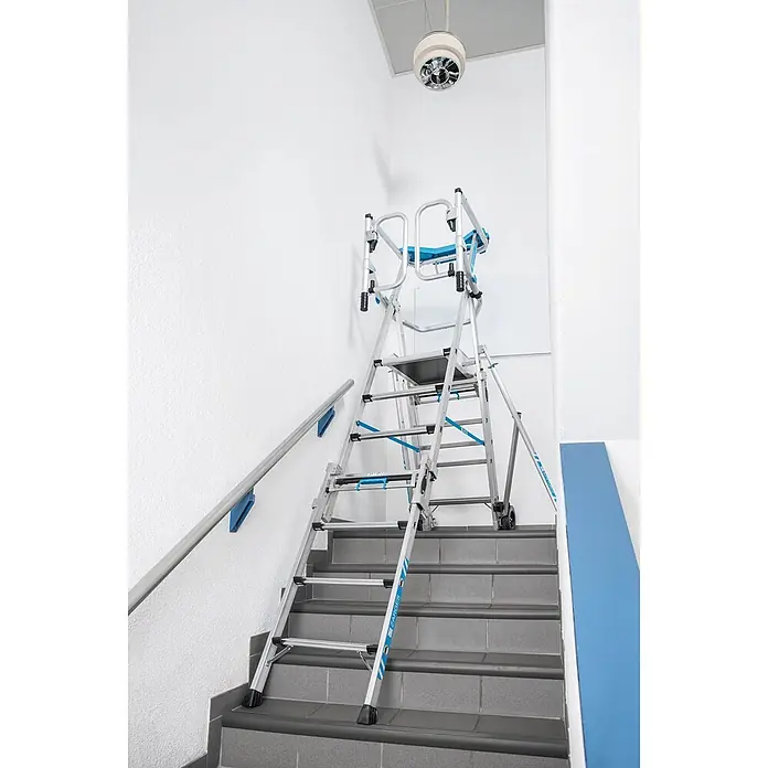 Zarges Teleskopleiter Teleskop Plattformleiter ZAP Masterflex Plus S gebördelt 3-5 Stufen - Anzahl Tritte: 5 Stk., Arbeitshöhe: 3.280 m, Belastbarkeit: 150 kg, Aluminium - Aluminium-Arbeitsplattform in Silber mit blauen Akzenten auf einer Treppe. Für sicheres Arbeiten in der Höhe auf Stufen.