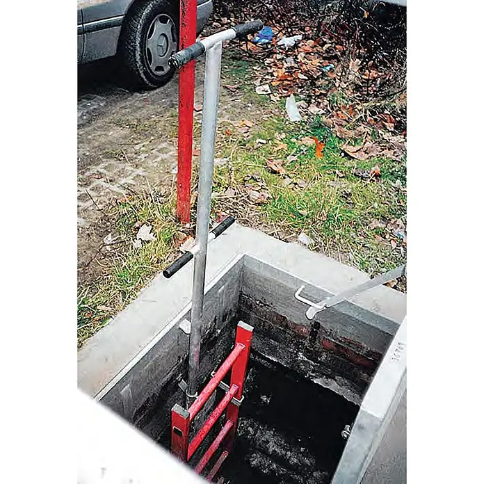Zarges Steigleiter Schachtleiter 300mm lichte Breite GFK, 9 Sprossen - Anzahl Tritte: 9 Stk., Kunststoff - Silberne Sicherheitsstange mit schwarzen Griffen und roter Leiter an einem offenen Schacht für sicheren Zugang.