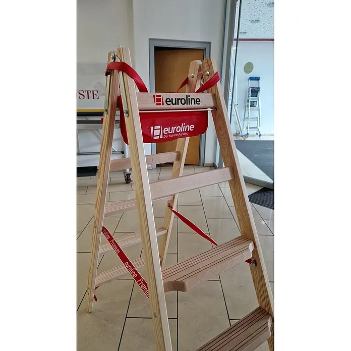 Euroline Stehleiter Holz Stufenstehleiter mit 2x5 Comfort-Stufen mit Werkzeugablage + passende - Anzahl Tritte: 5 Stk., Arbeitshöhe: 2.750 m, Holz - Stehleiter aus hellem Holz mit roten Gurten und roter Euroline Aufbewahrungstasche.