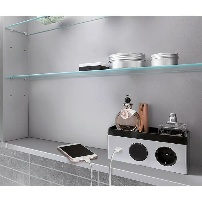 Camargue Stella LED-Spiegelschrank - B x H: 70 x 73,7 cm, Holz, Weiß, Mit Beleuchtung, Kantenausführung Tür: Abgerundet - Ein Badezimmerschrank mit Glasregalen, in dem diverse Badutensilien wie Parfüm und eine Ladestation für ein Smartphone aufbewahrt werden.