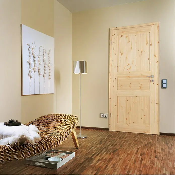 Kilsgaard Landhaustür 02/03860 x 1.985 mm, DIN Anschlag: Links, Kiefer natur - Elegante Holztür mit Paneelen und silberner Türklinke in einem stilvollen Interieur. Die Tür harmoniert perfekt mit dem Holzboden.