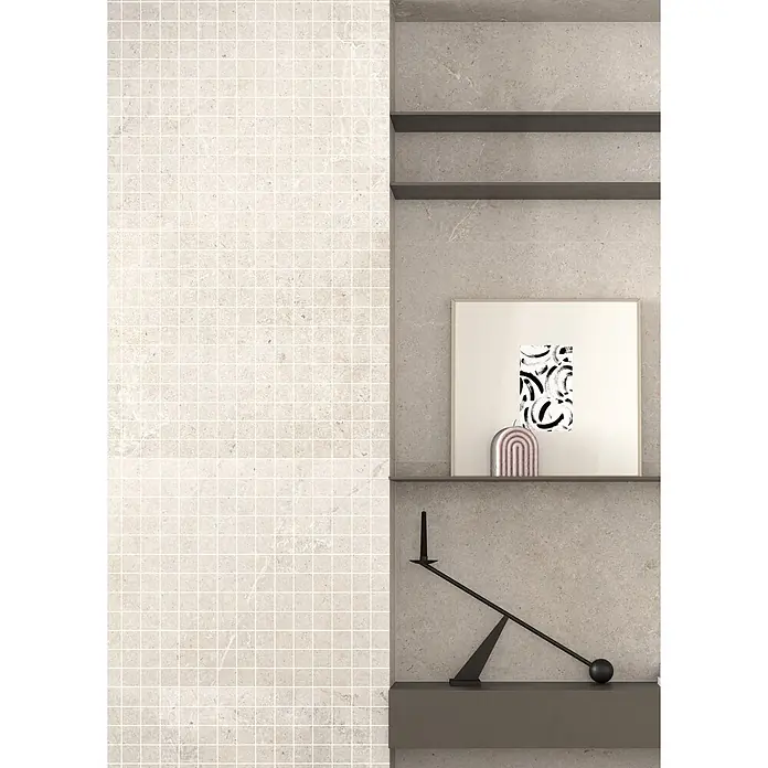 RAK Ceramics Valdi Mosaikfliese - 30 x 30 cm, White, Matt - Modernes Interieur mit Mosaikwand und grauen Steinregalen, darauf abstrakte Kunst, ein roséfarbener Bogen und ein schwarzer Balance-Kerzenhalter.