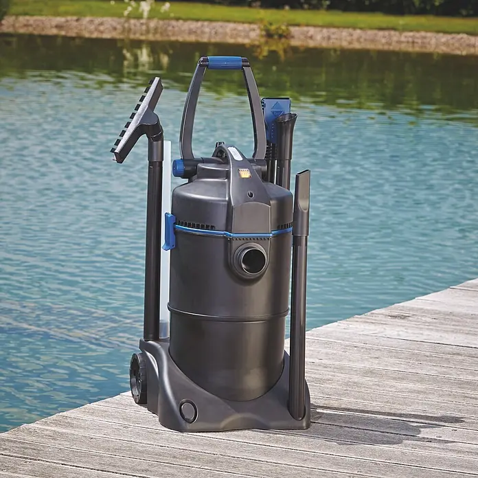 Oase Teichschlammsauger PondoVac 3 - 1.600 W, 27 l - Schwarz-blauer Teichsauger mit Zubehör auf einem Holzsteg am Wasser.
