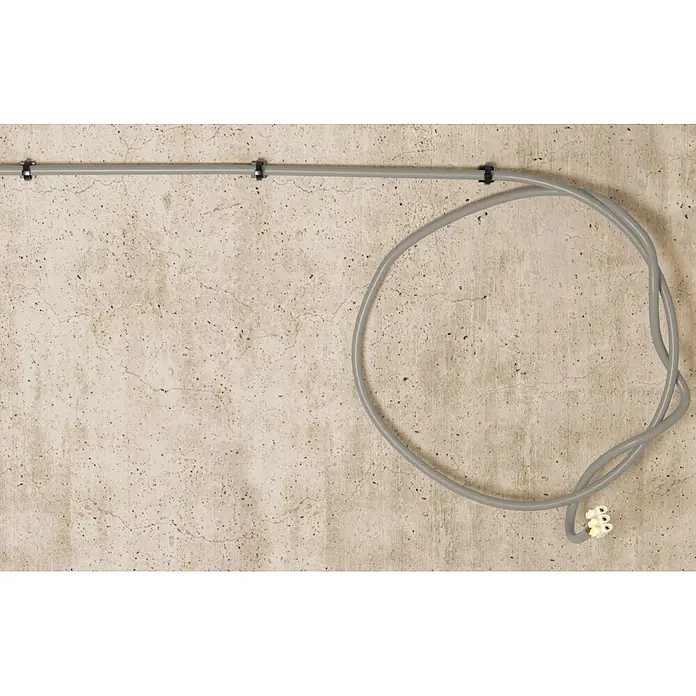Fischer Dübel Kabelbinderdübel FCTP - Schwarz, 100 Stk. - Graues Elektrokabel und -rohr, mit Klemmen an einer Betonwand befestigt, mit einem aufgerollten Abschnitt, der in einem Verbinder endet.