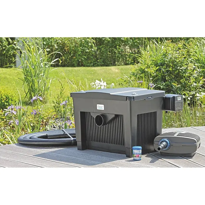 Oase BioSmart Durchlauffilter Set 18000 - 60 W, Teichgröße: 18 m³ - Schwarze Oase Teichfilteranlage mit UV-C-Einheit, Schlauch, Pumpe und BioKick auf Holzterrasse an einem Teich in einem sonnigen Garten.