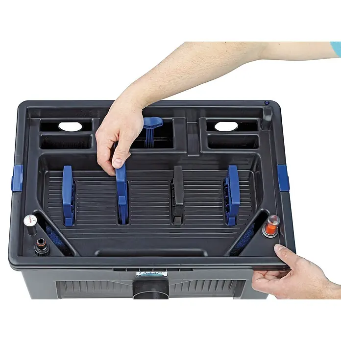 Oase BioSmart Durchlauffilter-Set 24000 - 24 W, Teichgröße: 24 m³, Fördermenge pro Std.: 5.300 l - Dunkelgrauer Teichfilterkasten mit blauen Innengriffen wird von Händen eingestellt. Mit Thermometer und roter Anzeige.