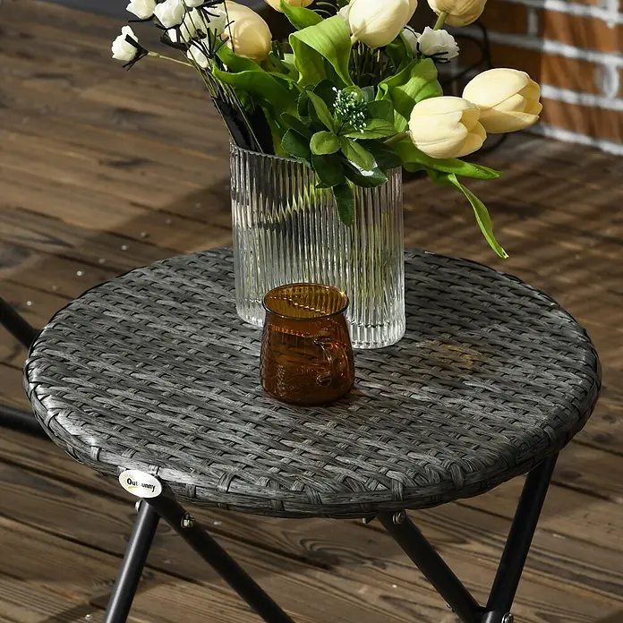 Outsunny Gartenstuhl-Set 3-teilig, mit Tisch -  - Runder grauer Rattan-Klappbeistelltisch auf Holzdeck mit Blumen und Tasse.