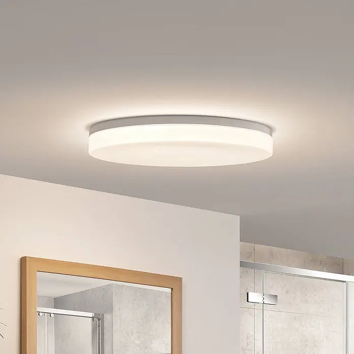 Prios Deckenleuchte Wynion - L x B x H: 50,5 x 50,5 x 8,74 cm, weiß / opal, weiß / opal - Runde LED-Deckenleuchte mit weißem Diffusor und silbernem Rand, an der Decke eines modernen Badezimmers montiert.