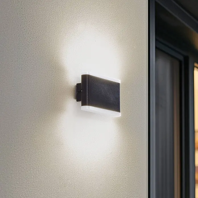 Lindby Außenwandleuchte Elvi - schwarz, IP54 - Schwarze rechteckige Außenwandleuchte mit weißen Diffusoren, an strukturierter Wand montiert, strahlt Licht nach oben und unten.