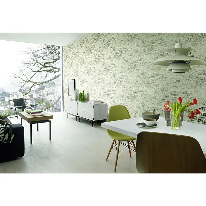 Rasch Vliestapete Bruchstein - Grau/Rostbraun, Steinoptik, 10,05 x 0,53 m - Einrichtungsidee mit weißem Sideboard und Esstisch mit Marmorplatte, sowie floralen Dekorationen und Blick ins Grüne.