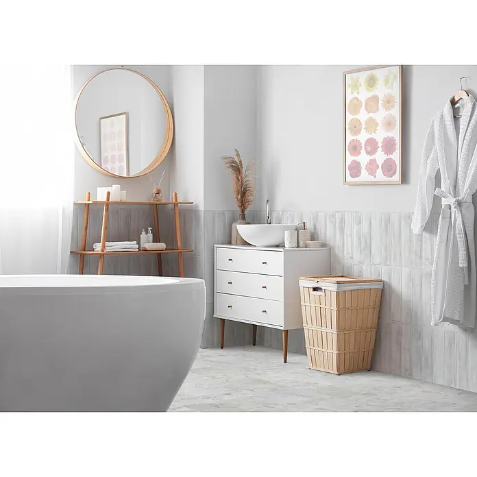 Wandfliese Livorno - 31 x 62 cm, Bianco, Glänzend - Ein helles, modernes Badezimmer mit einer weißen freistehenden Badewanne, einem Waschtisch mit Waschbecken, einem runden Holzspiegel und hellen Aufbewahrungselementen.
