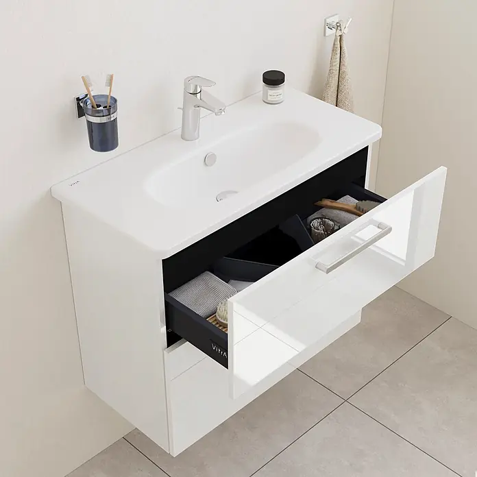 VitrA Root Flat Compact Badmöbel-Set Compact - B x T x H: 80 x 37 x 65 cm, Weiß, Hochglänzend - Weiße, wandmontierte Badunterschrank mit integriertem Waschbecken und Chromarmatur. Die geöffnete Schublade zeigt organisierte Fächer für Badutensilien.