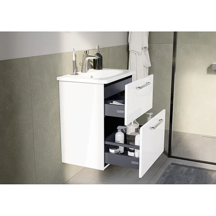 VitrA Root Flat Compact Badmöbel-Set Compact - B x T x H: 60 x 37 x 65 cm, Weiß, Hochglänzend - Weißer Badezimmer-Waschtisch mit integriertem Waschbecken und Chromarmatur. Offene Schubladen zeigen graue Organizer mit Badartikeln.