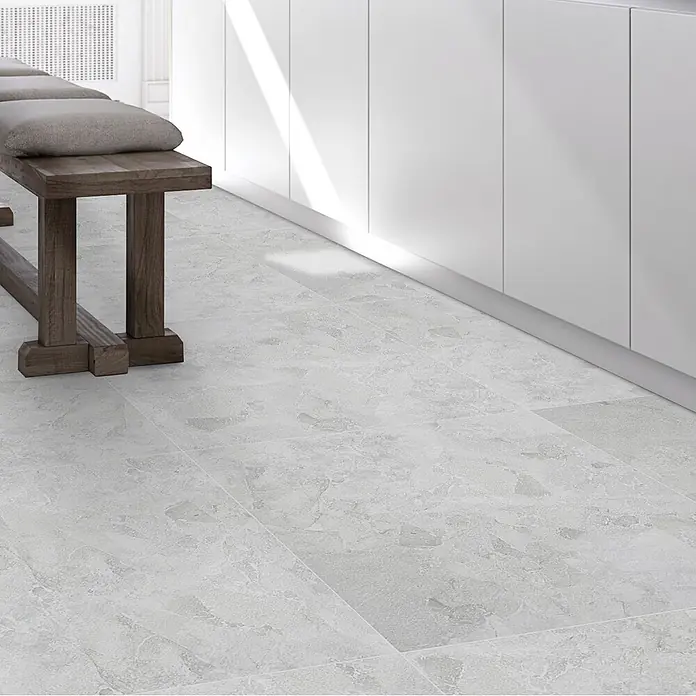 Feinsteinzeugfliese Monte - 60 x 60 cm, Bianco, Matt - Helle, steinoptische Bodenfliesen in einem modernen Raum mit Holzbank und weißen Schränken.