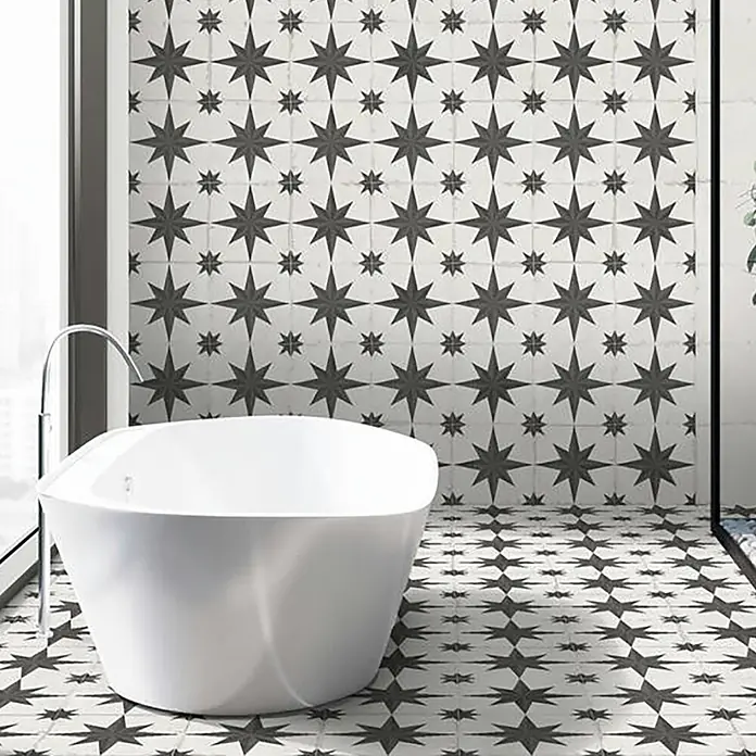 Feinsteinzeugfliese Chez Coco - 24,8 x 24,8 cm, Sun, Matt - Weiße freistehende Badewanne in einem modernen Badezimmer mit sternförmigen Wand- und Bodenfliesen.