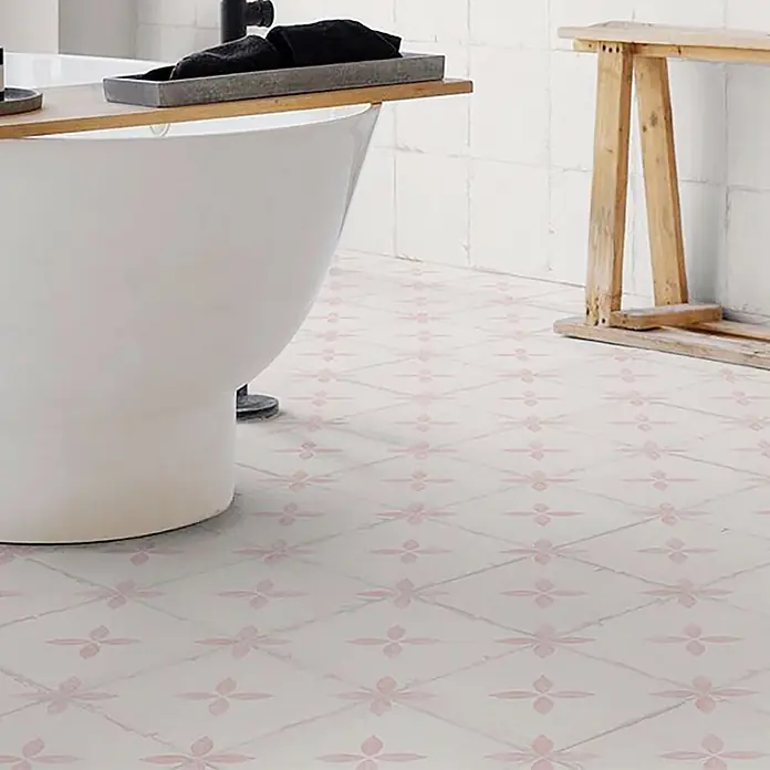 Feinsteinzeugfliese Sofia - 24,8 x 24,8 cm, Rosa, Matt - Weiße Badezimmerbodenfliesen mit wiederholtem rosa Blumenmuster, in einer Badezimmerumgebung.
