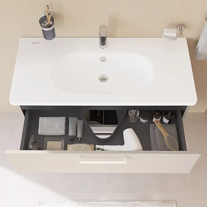 VitrA Badmöbel-Set Root Flat - B x T x H: 100 x 45 x 65 cm, Sahara Beige, Hochglänzend - Blick von oben auf einen modernen Badezimmerschrank mit weißem integriertem Waschbecken und offener beiger Schublade mit dunkelgrauen Organizern und Föhn.