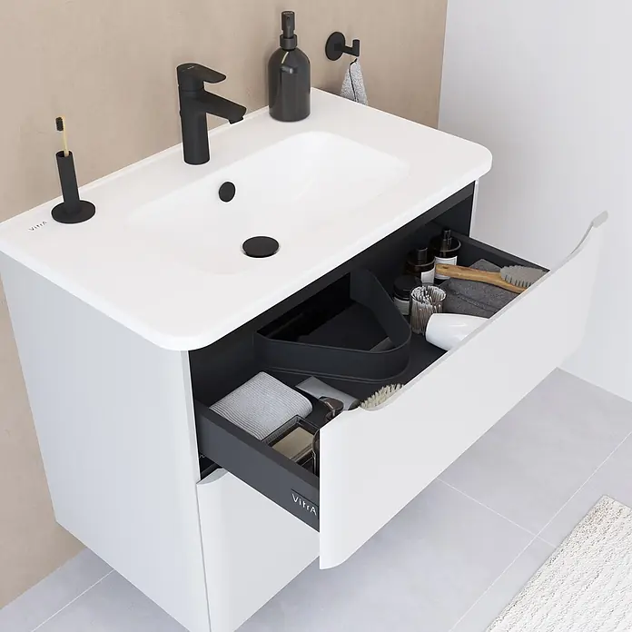 VitrA Integra Round Badmöbel-Set - Gesamtbreite Badmöbel: 80 cm, Hellgrau, Matt - Weißer Badunterschrank mit integriertem Waschbecken, schwarzer Armatur und geöffneter Schublade mit Organizer für Pflegeprodukte.