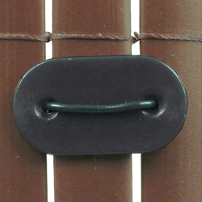 Nortene Clip de fijación Fixcane - Plástico, Negro, 26 ud. - Primer plano de un parche de cuero negro ovalado con un alambre de metal adjunto, formando un detalle decorativo sobre un fondo marrón.