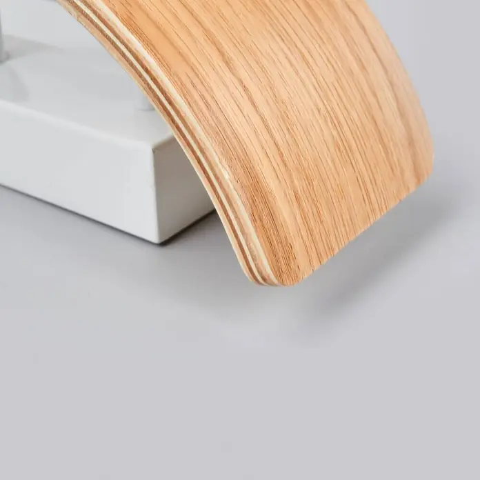 Lindby Wandleuchte Rafailia - Holz dunkel - Gebogenes helles Holzelement auf weißem rechteckigem Sockel.