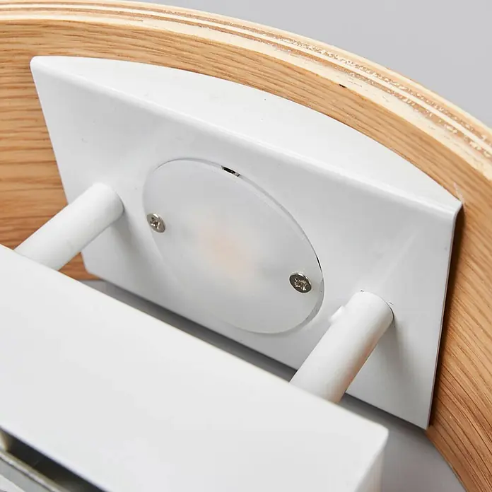 Lindby Wandleuchte Rafailia - Holz dunkel - Weißes Metall-Leuchtenbauteil mit mattiertem Diffusor und Verbindungsstangen, an einem gebogenen Schichtholzrahmen montiert.