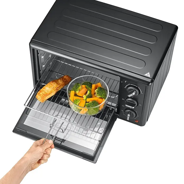 Severin Minibackofen TO2078 - Max. Leistung: 1.400 W, 20 l - Schwarzer Kompaktofen mit geöffneter Tür, Lachs und Gemüse innen, und einer Hand, die das Rost herauszieht.