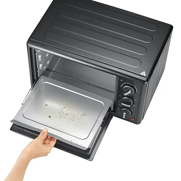 Severin Minibackofen TO2079 - Max. Leistung: 1.400 W, 20 l - Schwarzer Mini-Ofen mit geöffneter Tür, eine Hand zieht eine mit Krümeln gefüllte Metallschale heraus.