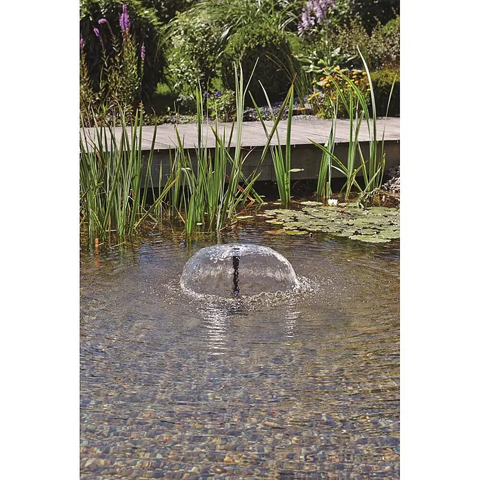Pontec Unterwasserfilter Pontec PondoRell 5000 UVC - Passend für: Filterung von Gartenteichen bis 5.000 Liter ohne Fischbesatz - Eine Wasserfontäne erzeugt einen kuppelförmigen Sprühstrahl in einem klaren Gartenteich, umgeben von üppigen Pflanzen.