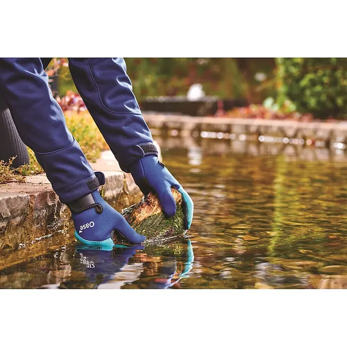 Oase Gartenhandschuhe PondGloves Teichhandschuhe - L, Blau - Blaue und türkise Oase Wasserhandschuhe an Händen, die einen moosigen Baumstamm im Wasser halten.